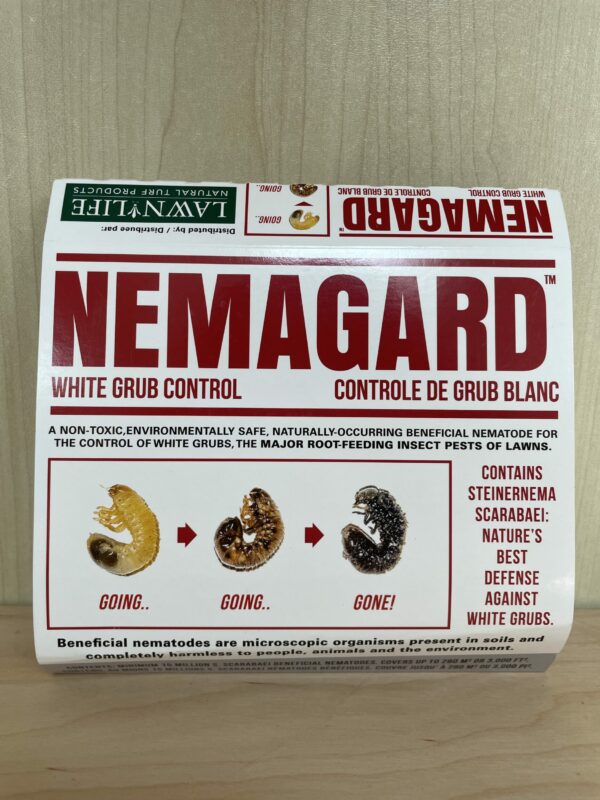 The image shows a box labeled "NEMAGARD WHITE GRUB CONTROL," advertising an environmentally safe nematode for pest control, specifically targeting white grubs.