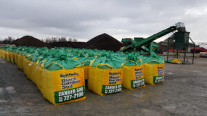 A large group of Big Yellow Bag totes with our screener/bagger in the background