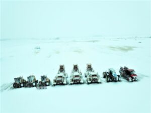 Harvesters, forklifts parked in the field surrounded with snow