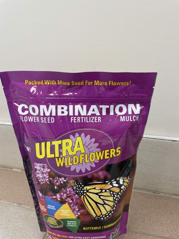 A purple bag of pollinator wildflower seeds with fertilizer and mulch.